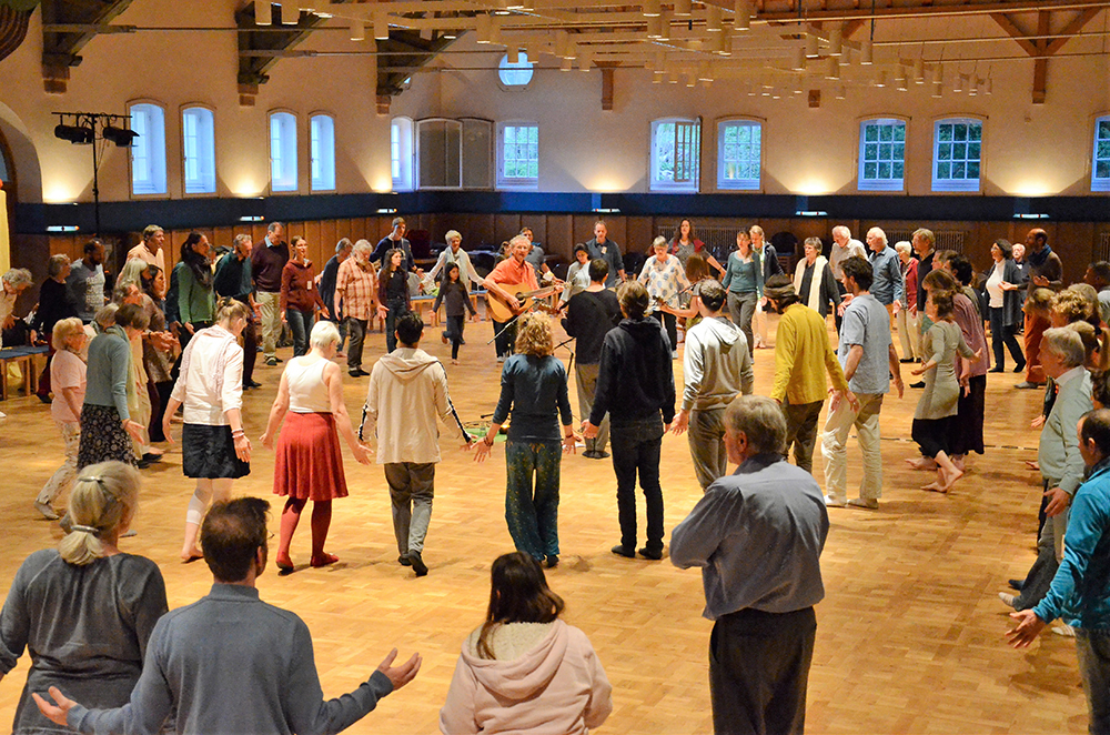 Bild einer Gruppe in einer Halle, die eine Sufi-Meditation betreibt